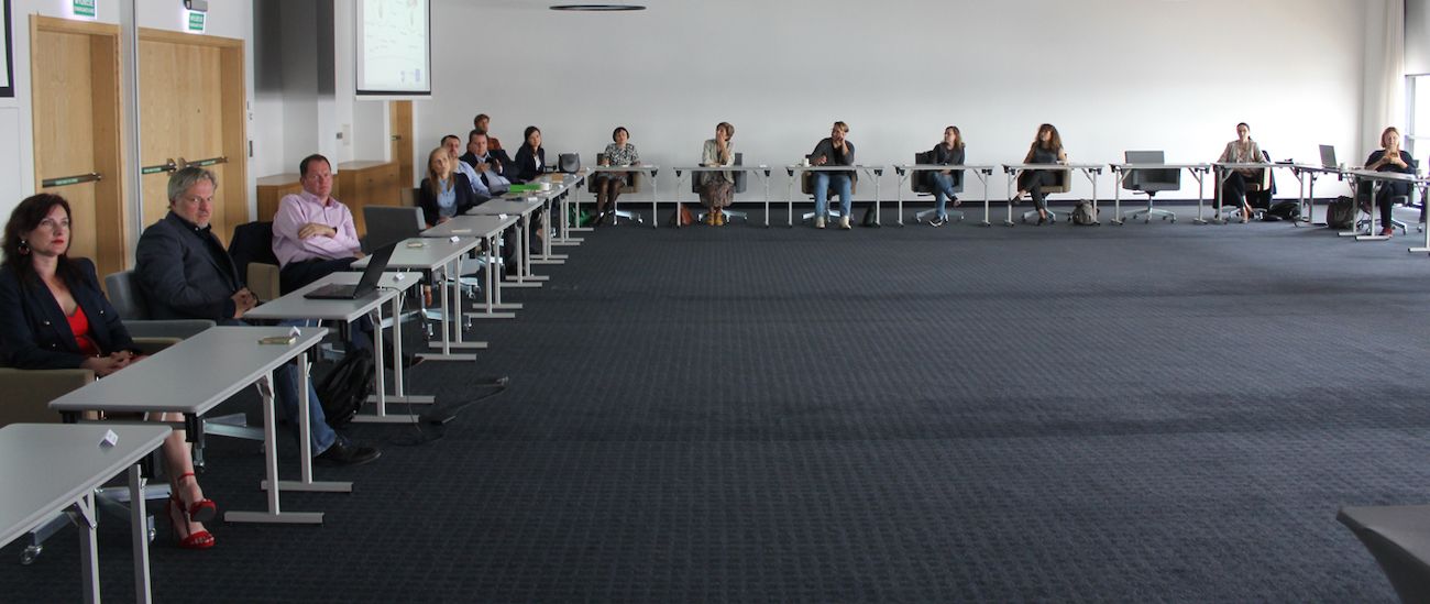 People sitting with disctance in a room due to corona